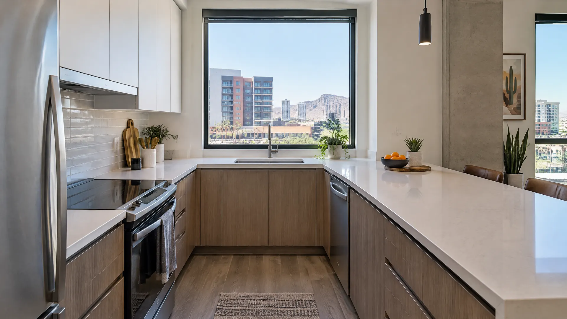 Compact modern condo kitchen in downtown Tempe, Arizona with flat-panel cabinets, quartz counters and a window looking out at mid-rise buildings